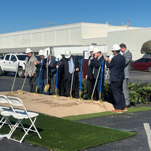 Men in hard hats and suits use golden shovels for the Biggs Park Mall groundbreaking ceremony