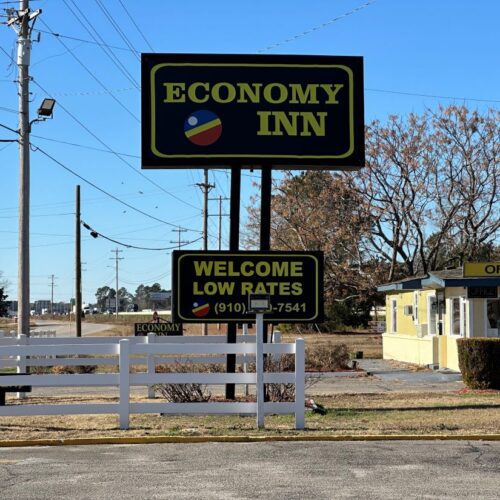 Roadside sign for the Economy Inn motel that offers low rates in Lumberton, NC