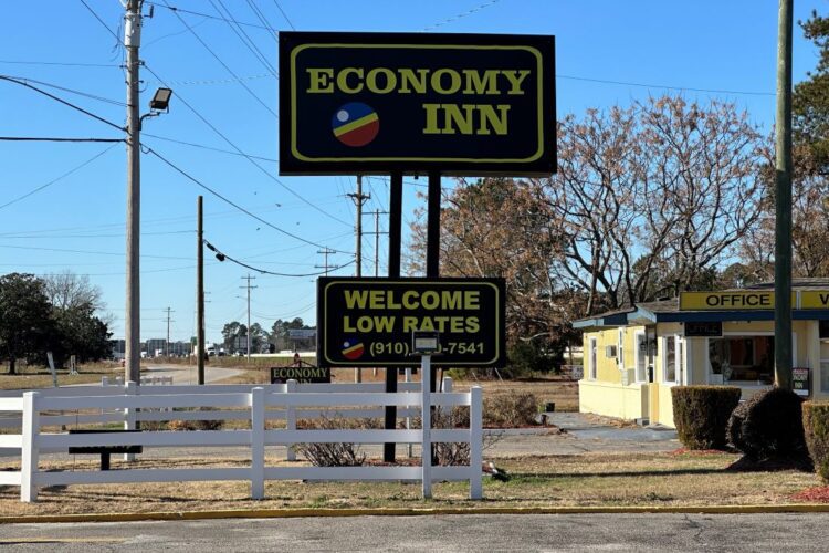 Roadside sign for the Economy Inn motel that offers low rates in Lumberton, NC