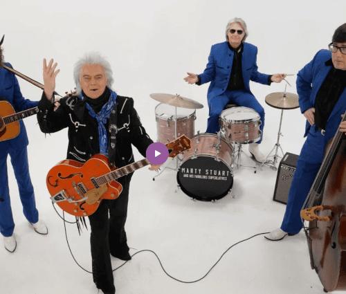 A band of men in blue and black suits all pausing their instrument playing with looks of exasperation on their faces.