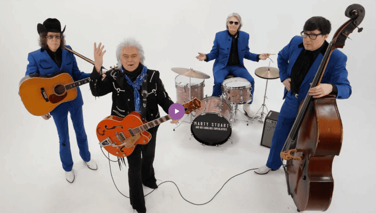 A band of men in blue and black suits all pausing their instrument playing with looks of exasperation on their faces.