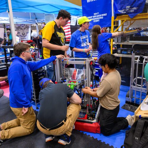 Group of students working on a robot at the Robotics FIRST Pembroke event